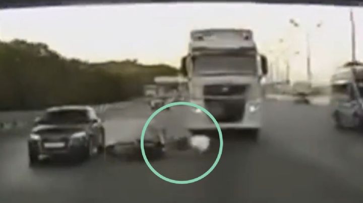 Se salvó de milagro: hombre se cae de su moto a alta velocidad y casi lo atropella un tráiler | VIDEO