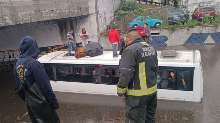 VIDEO: Camión de pasajeros se queda varado en un bajo puente de Tlalnepantla, por inundaciones